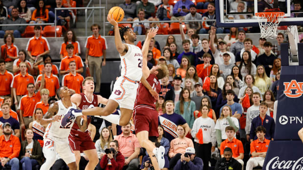 Dec 2, 2022; Auburn, Alabama, USA; Auburn Tigers forward Yohan Traore (21) takes a shot over Colgate Raiders forward Ryan Moffatt (4) during the first half at Neville Arena. Mandatory Credit: John Reed-USA TODAY Sports